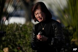 Judy Man cries near a memorial outside Monterey Park City Hall, blocks from the Star Ballroom Dance Studio on Tuesday, Jan. 24, 2023, in Monterey Park, California.
