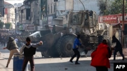 Sejumlah warga Palestina tampak melempar batu ke arah buldoser milik tentara Israel dalam bentrokan di Kota Jenin, Tepi Barat, pada 26 Januari 2023. (Foto: AFP/Zain Jaafar)