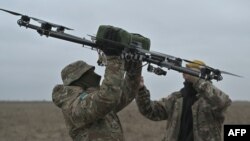 ARHIVA - Piloti nose dron na trenažnom poligonu tokom ruske invazije na Ukrajinu, u Kijevu, 23. februara 2024,