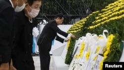 Perdana Menteri Jepang Fumio Kishida meletakkan karangan bunga bagi para korban bom atom 1945, dalam sebuah upacara untuk menandai ulang tahun ke-77 bom atom pertama di dunia di Hiroshima, di Peace Memorial Park Hiroshima, Jepang 6 Agustus 2022.