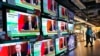 People stand by TV screens broadcasting the news of Russian invasion of Ukraine, in Hong Kong, Feb. 24, 2022. (AP/Vincent Yu)