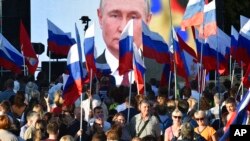 Orang-orang berkumpul di depan layar besar untuk merayakan penggabungan wilayah Ukraina ke Rusia, di Sevastopol, Krimea, 30 September 2022. (Foto: AP)