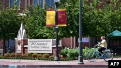 Seorang pengendara sepeda di University of Southern California (USC), Los Angeles, California, 25 Agustus 2020 (Frederic J. BROWN / AFP)