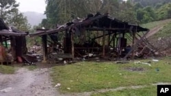 Puing-puing berserakan di sekitar bangunan kayu yang hancur di dekat Desa Aung Bar Lay, kotapraja Hpakant, negara bagian Kachin di Myanmar Senin, 24 Oktober 2022. ( AP)