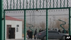 FILE - Residents line up inside the Artux City Vocational Skills Education Training Service Center, which was revealed by leaked documents to be a forced indoctrination camp at the Kunshan Industrial Park in Artux in western China's Xinjiang region, Dec. 3, 2018.