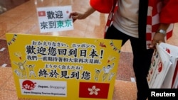 日本一家旅游公司的员工在羽田机场欢迎一个香港旅游团。（2022年6月26日）