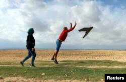 Imen Hbiri, salah satu pendiri startup Robocare, melihat seorang rekannya menerbangkan drone di sebuah peternakan pertanian di Kasserine, Tunisia, 6 Oktober 2022. (REUTERS/Jihed Abidellaoui)