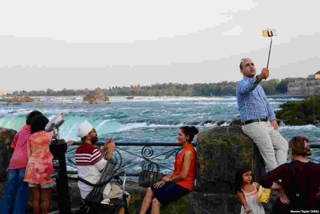 International tourists pose beside Horseshoe Falls in Niagara Falls, Ontario. (R. Taylor/VOA)