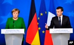 FILE - In this March 23, 2018, file photo, French President Emmanuel Macron, right, and German Chancellor Angela Merkel speak at a news conference in Brussels.