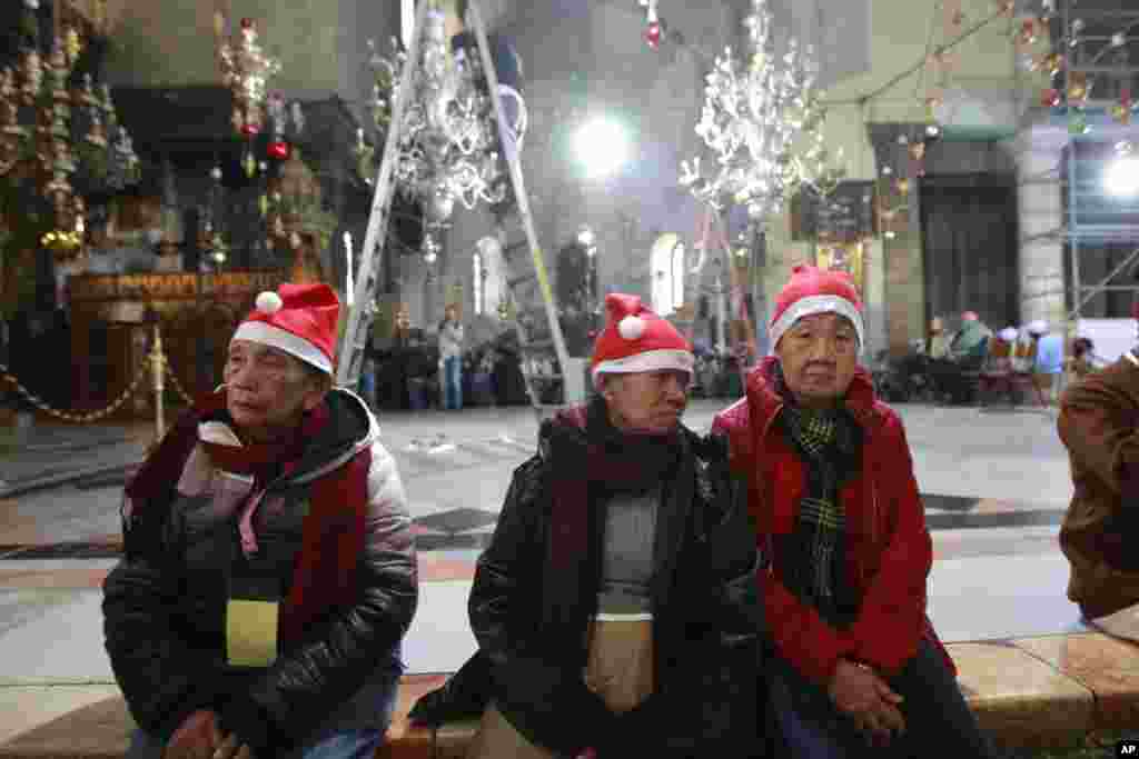 Jemaat mengunjungi Gereja Nativity, yang secara tradisional diyakini umat Kristiani sebagai tempat kelahiran Yesus Kristus, di Bethlehem, Tepi Barat, pada Malam Natal (24/12). (AP/Majdi Mohammed)