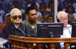 In this photo released by the Extraordinary Chambers in the Courts of Cambodia, the two most senior surviving members of the Khmer Rouge regime Nuon Chea, left, and Khieu Samphan listen to the verdict which upheld their life sentences.