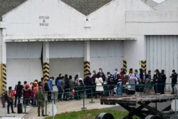 Portuguese border police officers check the documents of Afghan passengers who disembarked from an airplane at Lisbon military airport, Dec. 13, 2021.