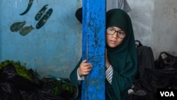 A girl observes the market area of al-Roj Camp, where mostly women from western countries believed to be part of the former IS are held Northeast Syria, on Oct. 13, 2024. (Yan Boechat/VOA)