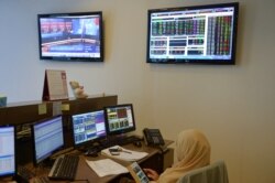 Seorang pialang perempuan sedang mengecek gawainya saat sesi perdagangan di sebuah kantor perusahaan sekuritas di Jakarta, 9 Februari 2016. (Foto: AFP)