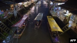 This picture taken on March 28, 2015 shows boats carrying visitors along the Amphawa canal, a small tributary of the Mae Khlong River, in Samut Songkhram province some 80 kilometers west of Bangkok. 