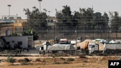 Truk-truk yang membawa bantuan kemanusiaan dari Mesir menunggu di wilayah Palestina di penyeberangan perbatasan Rafah di bagian selatan Jalur Gaza, 1 November 2023. (Foto: Mohammad Abed/AFP)