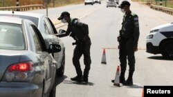 Pripadnici izraelskih bezbednosnih snaga zaustavljaju automobili u sklopu napora da uhvate šest Palestinaca koji su pobegli iz zatatvora Gilboa ranije ove nedelje, u blizini sela Mukeibila, u blizini ulaska u okupiranu Zapadnu obalu, 9. septembra 2021.