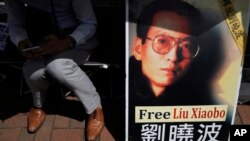 A protester displays a portrait of jailed Chinese Nobel Peace laureate Liu Xiaobo during a demonstration outside the Chinese liaison office in Hong Kong, July 11, 2017.