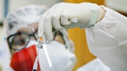 Seorang petugas kesehatan, yang menggunakan masker berwarna merah dan putih dalam rangka memperingati Hari Kemerdekaan Indonesia ke-76, menyiapkan vaksin COVID-19 merek Sinovac dalam program vaksinasi masal di Jakarta pada 17 Agustus 2021. (Foto: Reuters/Ajeng Dinar Ulfiana)