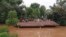FILE - Villagers take refuge on a rooftop above flood waters from a collapsed dam in the Attapeu district of southeastern Laos, July 24, 2018.
