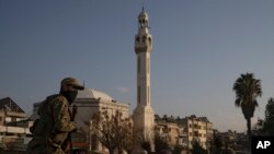 叙利亚新政府安全部队一名成员在叙利亚霍姆斯市安全检查站附近地区巡逻。(2024年12月26日)