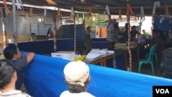 Warga menyaksikan kegiatan penghitungan suara di TPS 5 desa Maliwuko Kecamatan Lage, Kabupaten Poso, Sulawesi Tengah (17 April 2019). (Foto: VOA/Yoanes Litha)