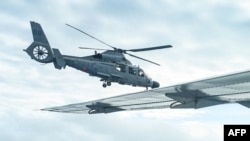 Helikopter Angkatan Laut China terbang di dekat pesawat Biro Perikanan dan Perairan Filipina di atas wilayah Scarborough Shoal di Laut China Selatan, pada 18 Februari 2025. (Foto: AFP/Jam Sta Rosa)