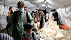 Evacuated citizens from Afghanistan arrive at Tirana International Airport in Tirana, Albania, Friday, Aug. 27, 2021. Albania agreed to host Afghan refugees while they are being vetted for visas for the US.