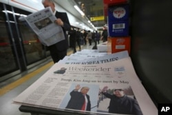 FILE - A newspaper with a headline of a planned summit meeting between North Korean leader Kim Jong Un and U.S. President Donald Trump is seen at subway station in Seoul, South Korea, March 10, 2018.