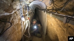 FILE- An Israeli army officer shows journalists a tunnel allegedly used by Palestinian militants for cross-border attacks from Gaza into Israel, July 25, 2014.