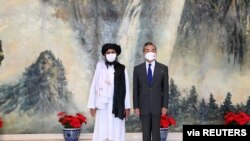 Menteri Luar Negeri China Wang Yi (kanan) bertemu dengan pemimpin politik Taliban Mullah Abdul Ghani Baradar dalam sebuah pertemuan di Tianjin, China, pada 28 Juli 2021. (Foto: Xinhua News Agency via Reuters) 