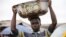 A man balances a bowl with a print of the old Nigerian naira banknote on his head at a local market in Agege district in Lagos, Nigeria, Aug. 16, 2016.