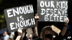 FILE - Ribuan orang berunjuk rasa dengan membawa plakat dan spanduk, menuntut keadilan bagi perempuan di Sydney, Senin, 15 Maret 2021.