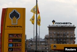 Logo produsen minyak mentah utama Rusia Rosneft terlihat di papan informasi harga sebuah pompa bensin di Moskow, 17 Juli 2014. (Foto: Reuters)