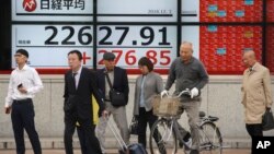 Papan elektronik sebuah kantor sekuritas di Tokyo, Jepang, menampilkan indeks bursa saham di lantai bursa pasar keuangan di Tokyo, 3 Desember 2018.