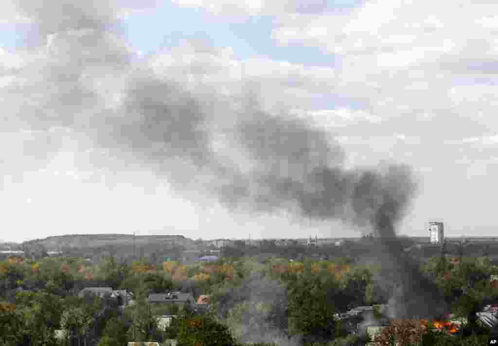 Smoke rises over a residential neighborhood near the airport after shelling in Donetsk, eastern Ukraine, Oct. 1, 2014.