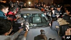 Law Wan-tung, a 44-year-old woman accused of torturing her Indonesian maid and two former domestic helpers, surrounded by photographers outside court, Hong Kong, Jan. 22, 2014.