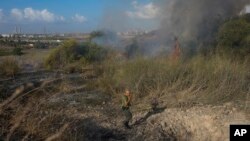 Seorang polisi memeriksa area kebakaran setelah militer menembakkan pencegat ke rudal dari Yaman yang jatuh di Israel tengah pada 15 September 2024. (Foto: AP)