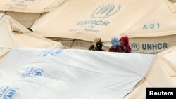 Displaced women, who fled from the Islamic State violence, gather at a refugee camp in the Makhmour area near Mosul, Iraq, June 17, 2016. 