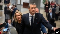 Pete Hegseth, President-elect Donald Trump's nominee to be defense secretary, is joined by his wife, Jennifer Rauchet, as they take an escalator in the Capitol, Dec. 4, 2024, in Washington.