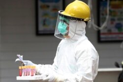 Seorang petugas kesehatan membawa sampel darah saat tes cepat virus corona di sebuah rumah sakit di Jakarta, 28 April 2020. (Foto: AP))