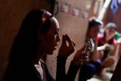 Adis, seorang transpuan, sedang merias wajah sebelum mengamen di rumahnya di perkampungan di Jakarta, 27 Januari 2012. (Foto: AP)