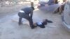  A still image taken from a video posted to a social media website on April 4, 2017, shows a man lying on the ground and being sprayed with water, said to be in the town of Khan Sheikhoun.