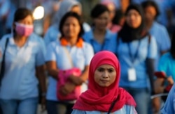 Seorang pekerja pabrik sepatu pulang kerja setelah pulang kerja, di kawasan industri Pasar Kemis di Tangerang, 13 Agustus 2014. (Foto: Reuters)