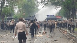 Mobil water canon Polda Sulawesi Tengah menyemprotkan air untuk membubarkan kerumunan mahasiswa yang sedang melakukan pelemparan batu kearah petugas dalam aksi unjuk rasa penolakan UU Cipta Kerja, Kamis, 8 Oktober 2020. (Foto: VOA/Yoanes Litha)