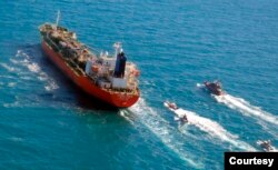 Kapal tanker berbendera Korea Selatan yang disita dikawal oleh kapal Garda Revolusi Iran di Teluk Persia. (Foto: via AP)