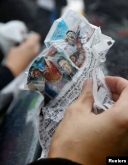 FILE - A journalist holds an anti-Pyongyang leaflet.
