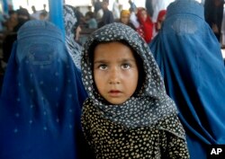Afghan refugees wait for their documents to go back to Afghanistan at the UNHCR's Repatriation Center in Peshawar, Pakistan on June 23, 2016.