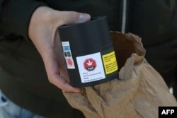 Seorang pelanggan memperlihatkan mariyuana yang dia beli di toko ganja di Kota Quebec, 17 Oktober 2018.