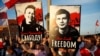 FILE - People hold placards depicting jailed Belarusian journalists Roman Protasevich and Ihar Losik as members of the Belarusian community gather to meet with Belarusian opposition leader Svetlana Tikhanovskayahave, in Warsaw, Poland, on June 3, 2021.